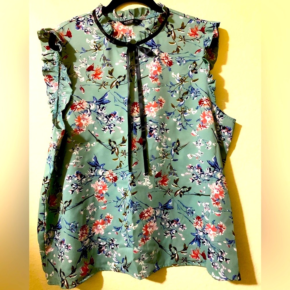 Polyester blouse with ruffle cap sleeves.